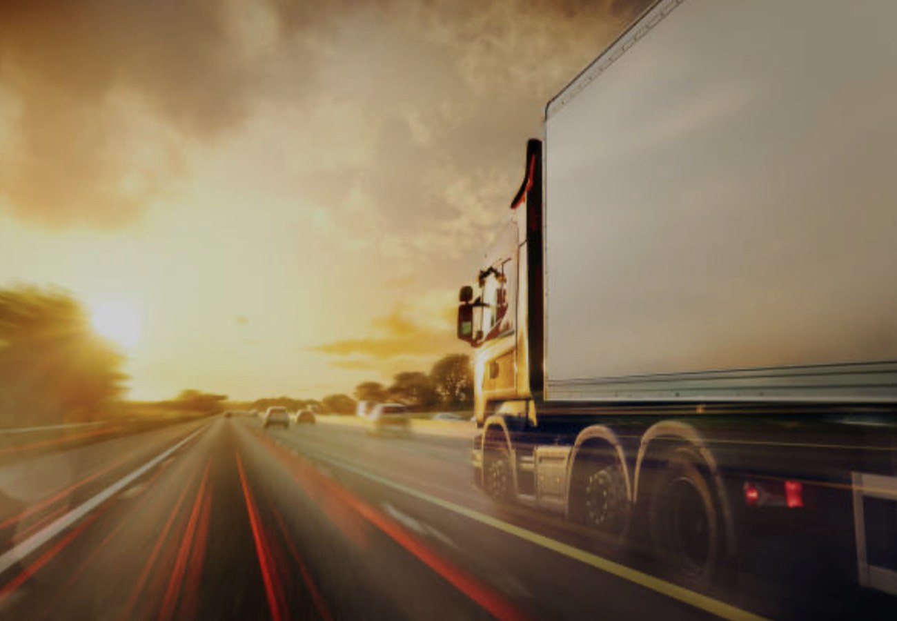 Poids lourd roulant sur l'autoroute au coucher du soleil